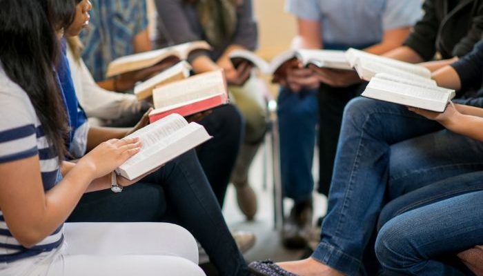 Jovens adolescentes reunidos lendo a Bíblia (Foto: Canva Pro)